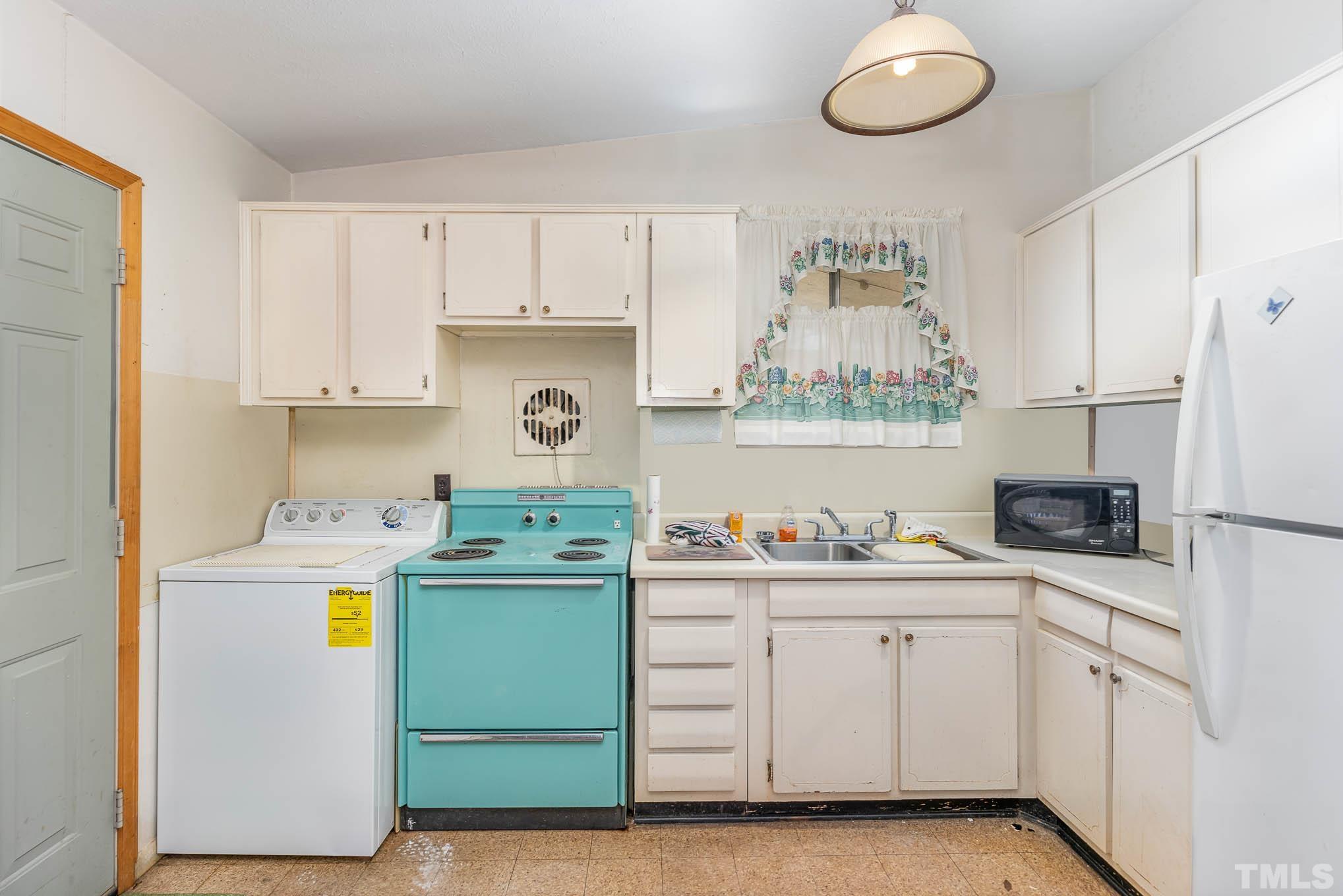 843 Hadley Road Raleigh, NC 27610 - Photo 10 of 28 a kitchen with a sink a stove and cabinets