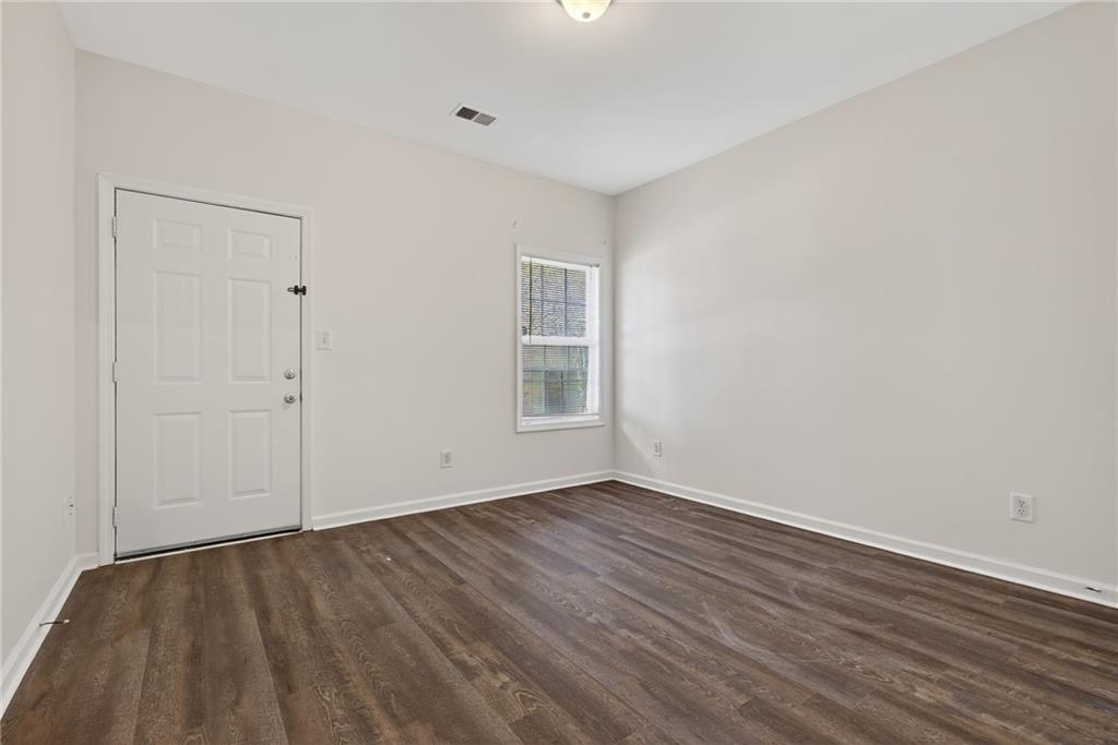 1644 Sandy Beach Point Lawrenceville, GA 30043 - Photo 11 of 60 a view of an empty room with wooden floor and a window