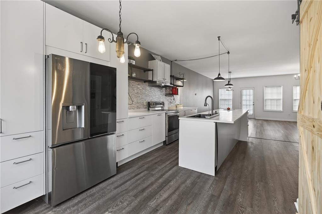1644 Sandy Beach Point Lawrenceville, GA 30043 - Photo 25 of 60 a kitchen with stainless steel appliances a refrigerator sink and cabinets