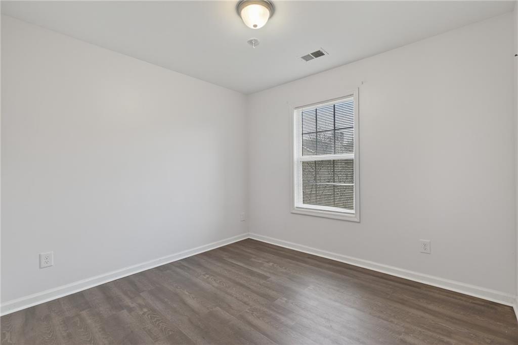 1644 Sandy Beach Point Lawrenceville, GA 30043 - Photo 49 of 60 an empty room with wooden floor and windows