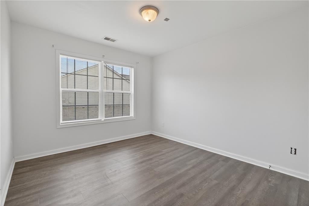 1644 Sandy Beach Point Lawrenceville, GA 30043 - Photo 52 of 60 an empty room with wooden floor and windows