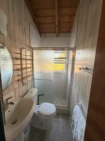 a bathroom with a sink a toilet and shower