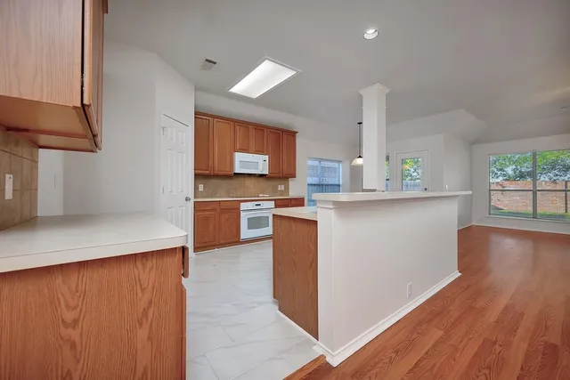 a kitchen with stainless steel appliances a sink a stove top oven a chimney and a center island