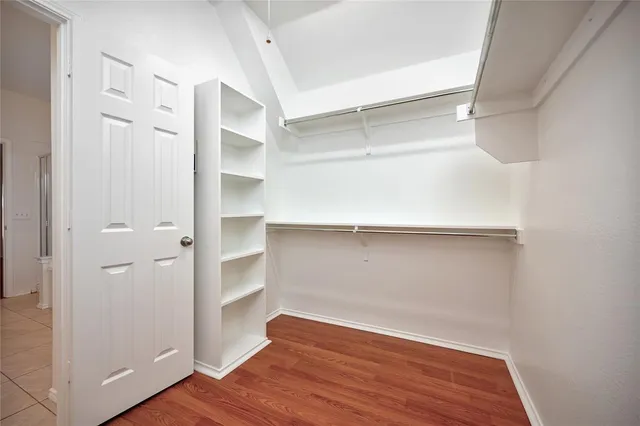 a view of walk in closet with wooden floor