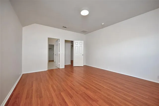 a big room with wooden floor and natural light