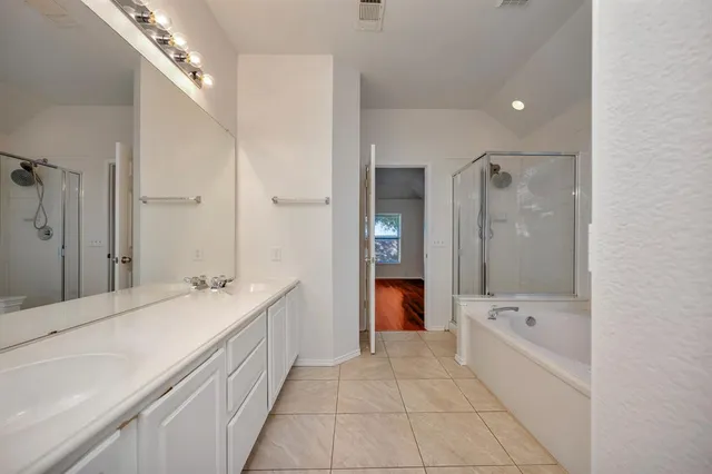 a bathroom with a bathtub shower and a sink