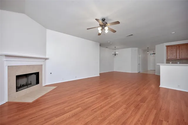 a view of empty room with wooden floor and fireplace