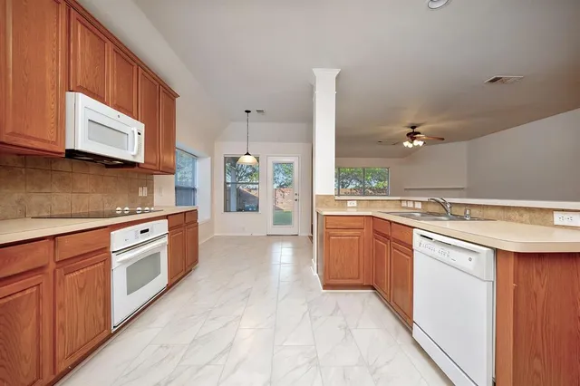 a large kitchen with stainless steel appliances granite countertop a sink and cabinets