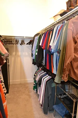 a view of walk in closet with clothes and shoes