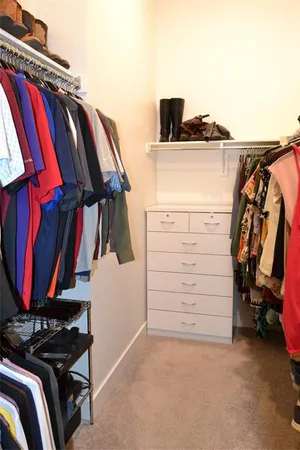 a view of walk in closet with clothes and shoes