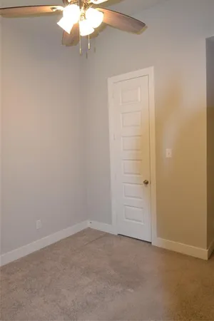 an empty room with a chandelier fan