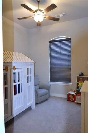 a living room with furniture and a ceiling fan