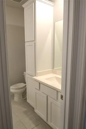 a bathroom with a granite countertop toilet and a sink