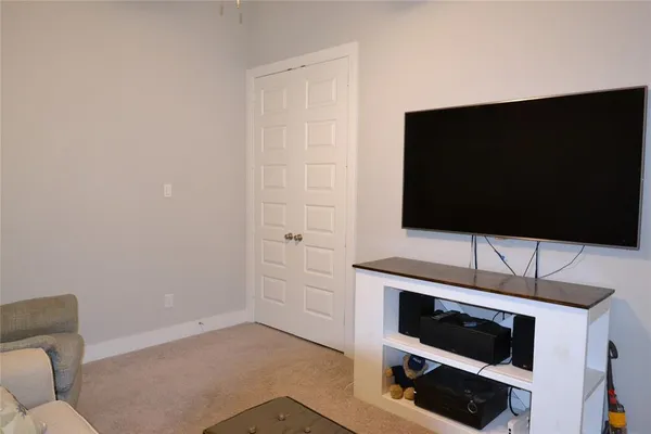 a living room with a flat screen tv and white appliances