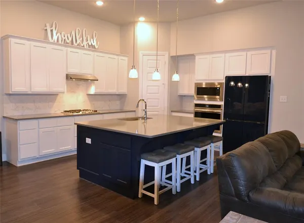 a kitchen with stainless steel appliances granite countertop a sink a stove a refrigerator and a cabinets