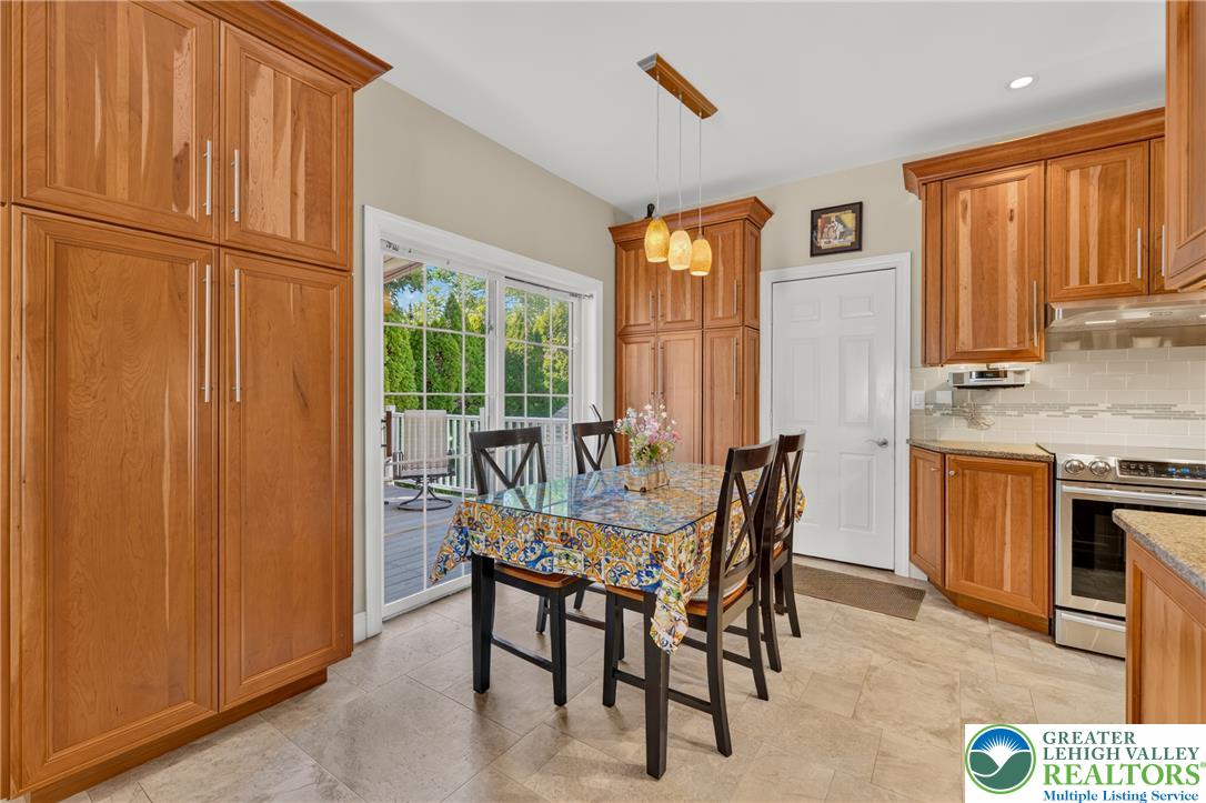 1702 Red Bud Road Quakertown, PA 18951 - Photo 18 of 68 A well-lit kitchen with natural wood cabinetry opens to a deck through sliding glass doors.