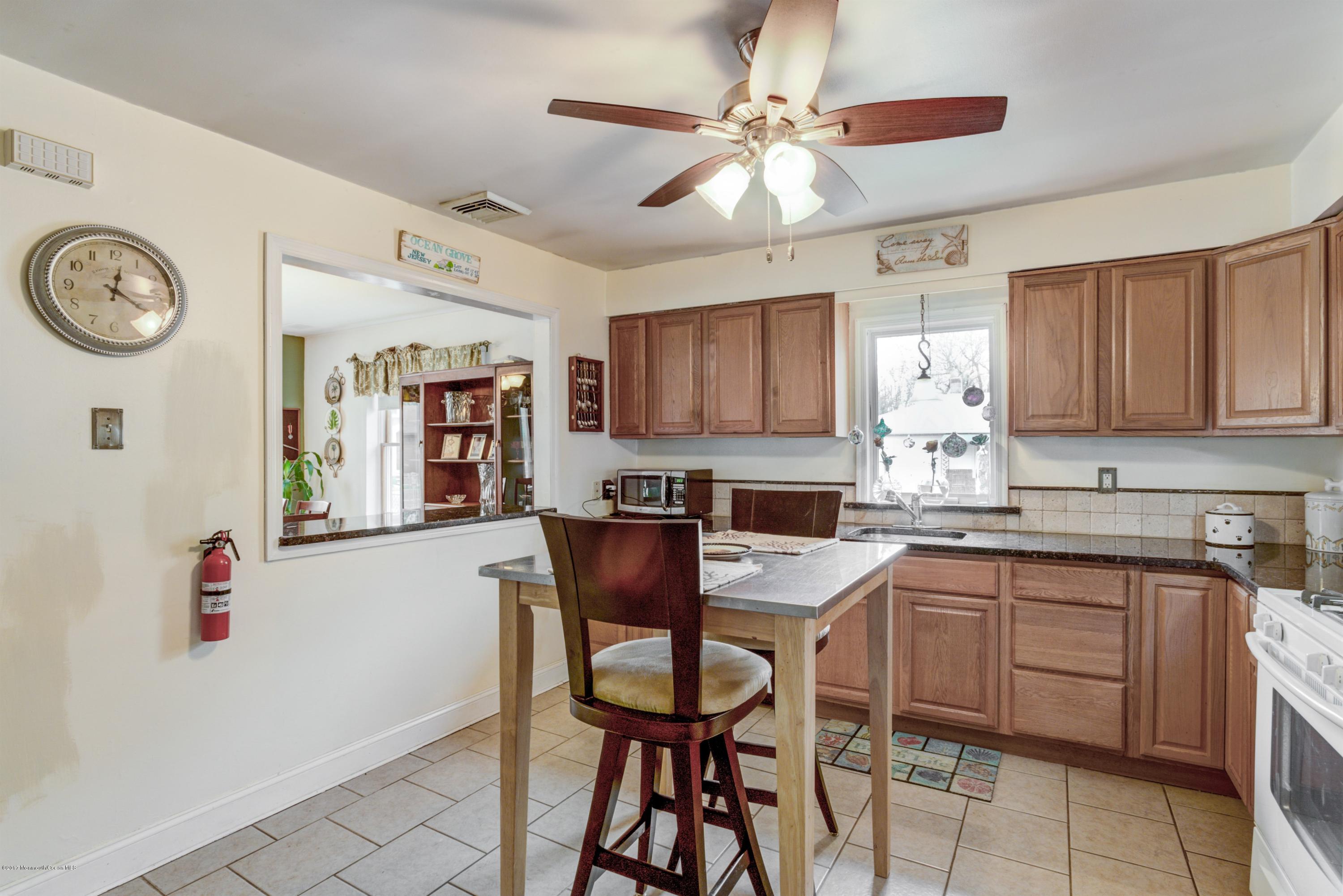 401 Stone Road Union Beach, NJ 07735 - Photo 14 of 26 a kitchen with a table chairs and a refrigerator