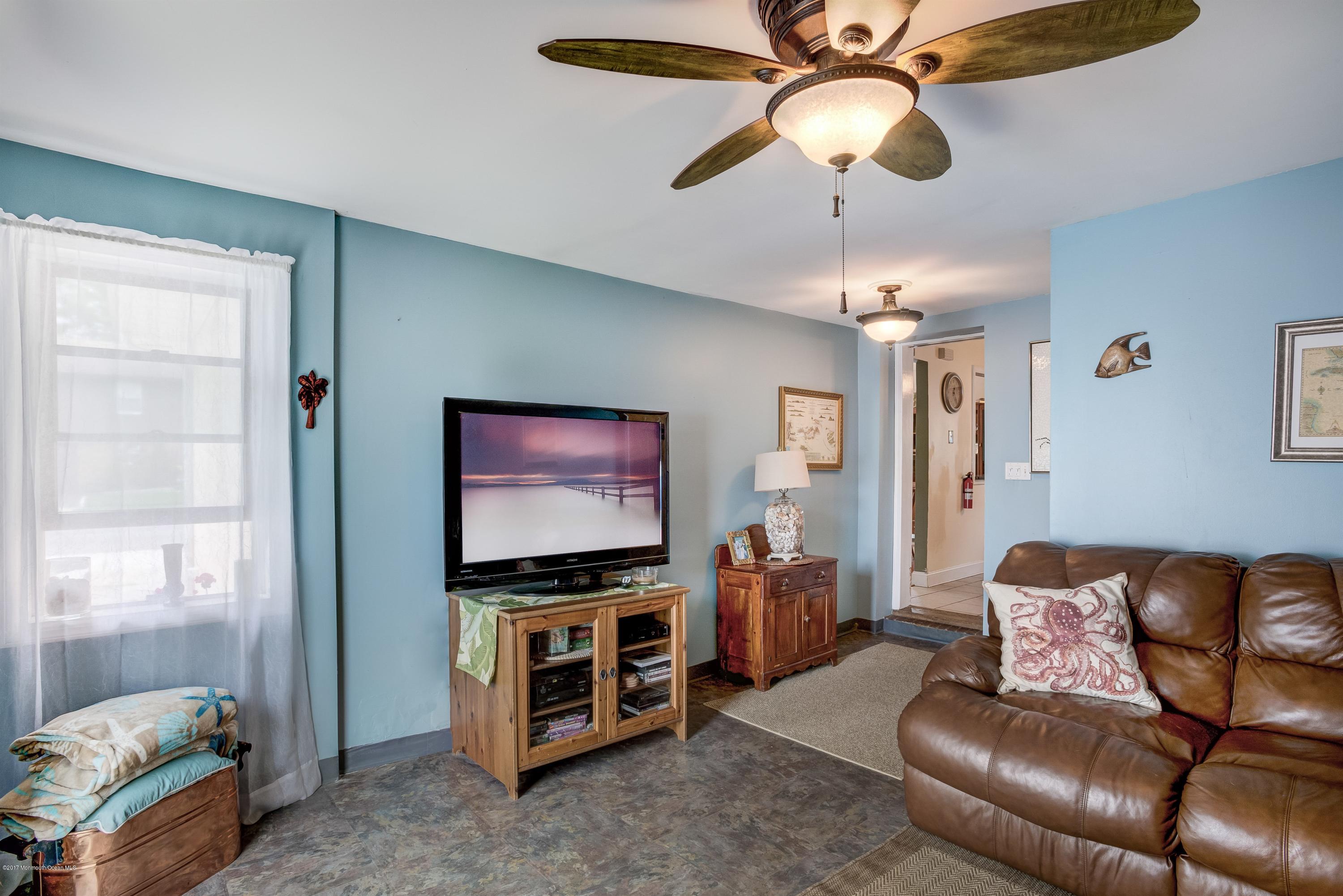 401 Stone Road Union Beach, NJ 07735 - Photo 20 of 26 a living room with furniture and a flat screen tv
