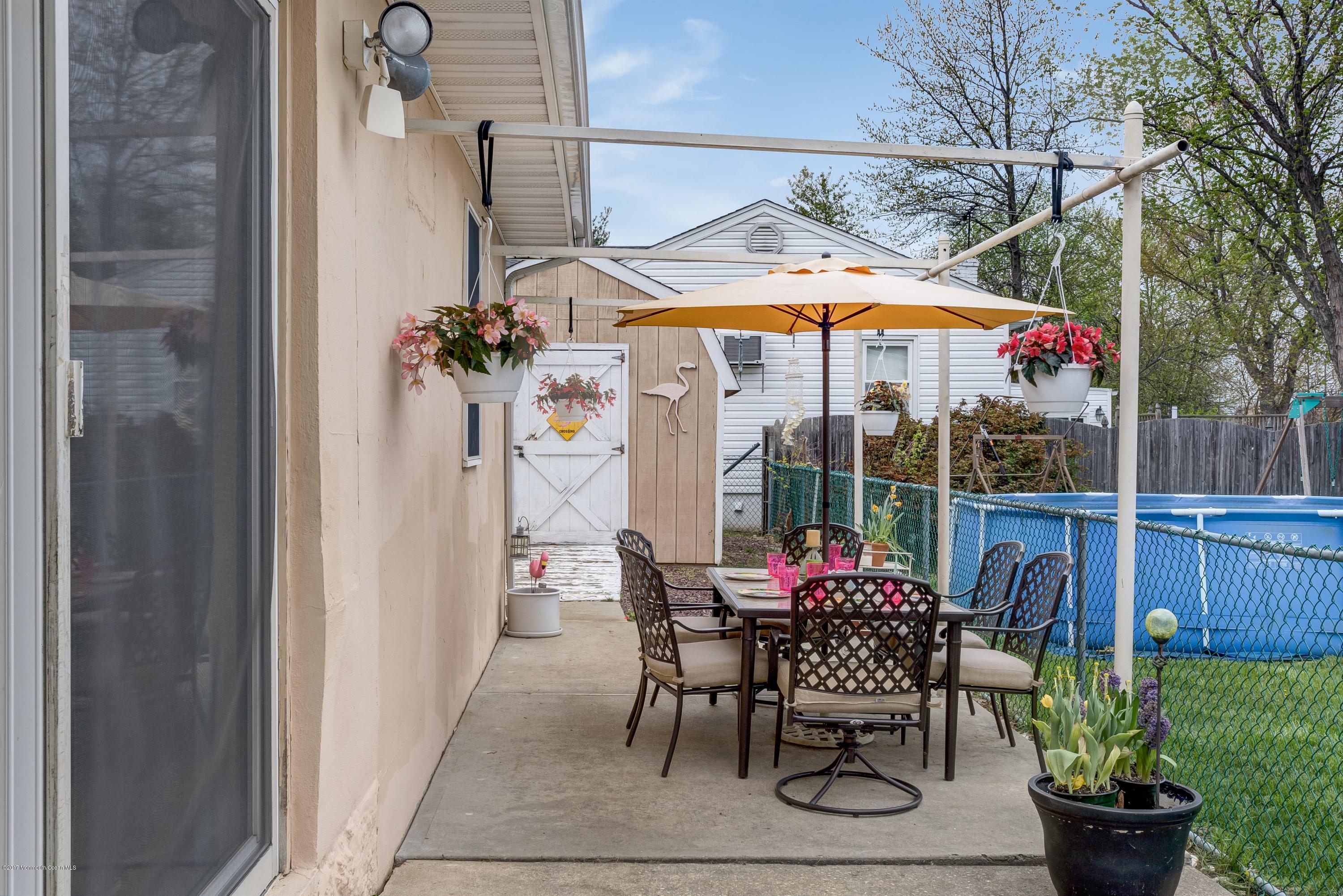 401 Stone Road Union Beach, NJ 07735 - Photo 26 of 26 a patio table with chairs and potted plants