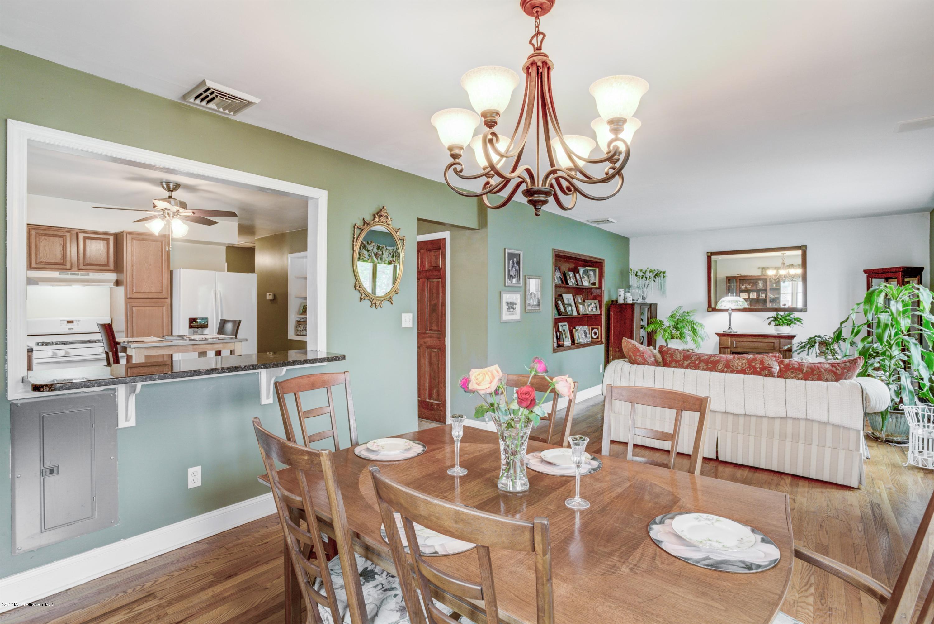 401 Stone Road Union Beach, NJ 07735 - Photo 3 of 26 a view of a dining room with furniture a chandelier and wooden floor