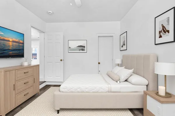 a spacious bedroom with a bed and a flat screen tv