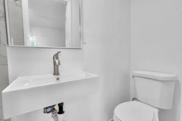 a bathroom with a toilet sink and mirror