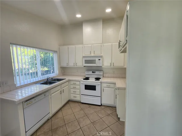a kitchen with a stove sink and cabinets