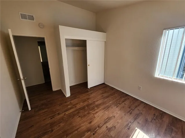 an empty room with wooden floor and entrance