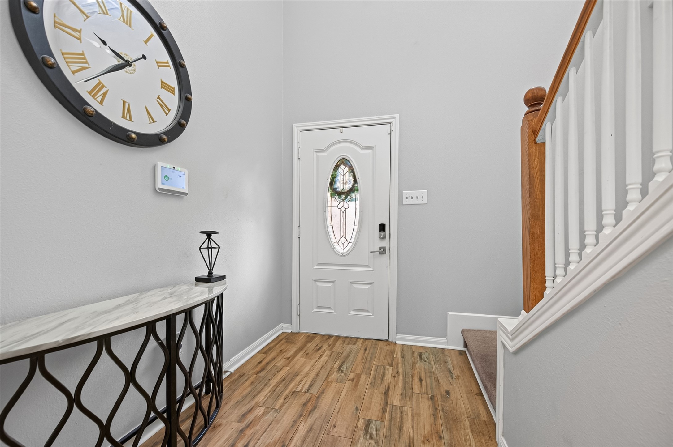 3418 Lockgate Drive Spring, TX 77388 - Photo 5 of 47 Stepping inside, you are greeted by a bright entryway featuring warm wood-look flooring. The staircase with its wood railing adds architectural interest, while the space flows easily toward the main living areas.