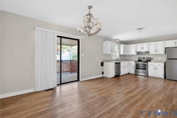 a kitchen with cabinets wooden floor and stainless steel appliances