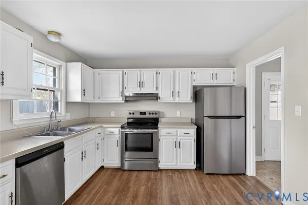 a kitchen with stainless steel appliances granite countertop a sink a stove and cabinets