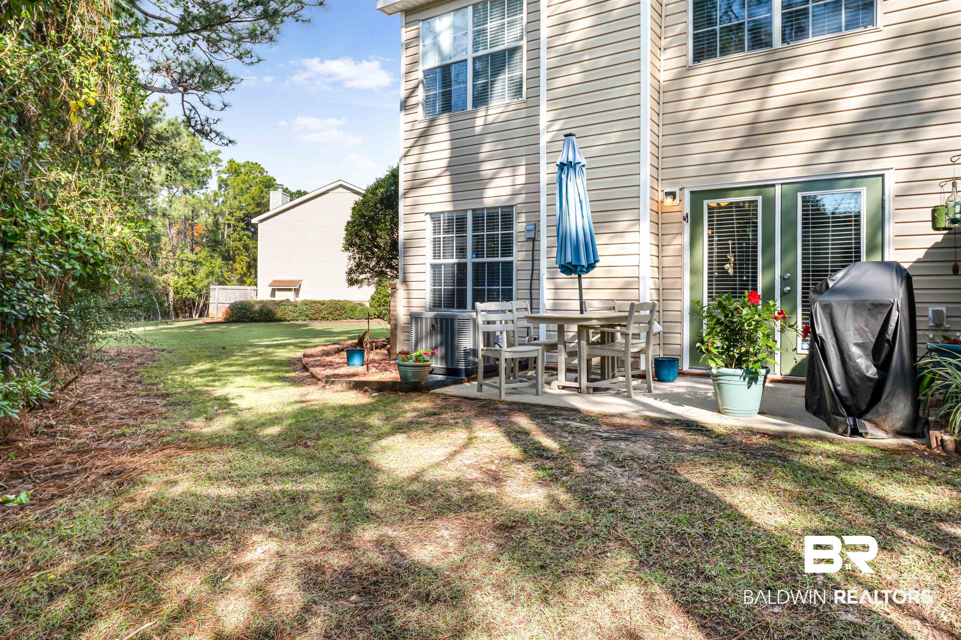 1517 Regency Road, Unit 68 Gulf Shores, AL 36542 - Photo 30 of 43 Back of house with a patio area and a yard
