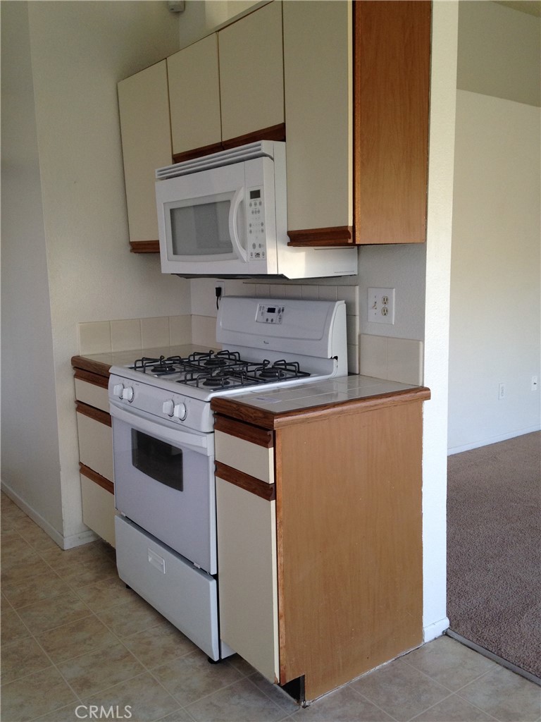 150 Elmtree Drive Perris, CA 92571 - Photo 6 of 10 a kitchen with cabinets appliances and a wooden floor
