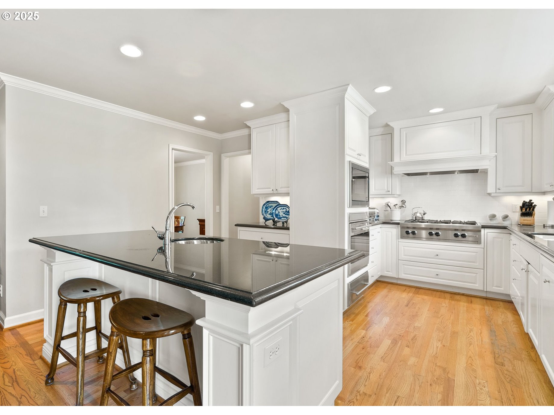 2100 Hillside Drive Lake Oswego, OR 97034 - Photo 5 of 40 a kitchen with stainless steel appliances granite countertop a sink a stove a refrigerator and white cabinets with wooden floor