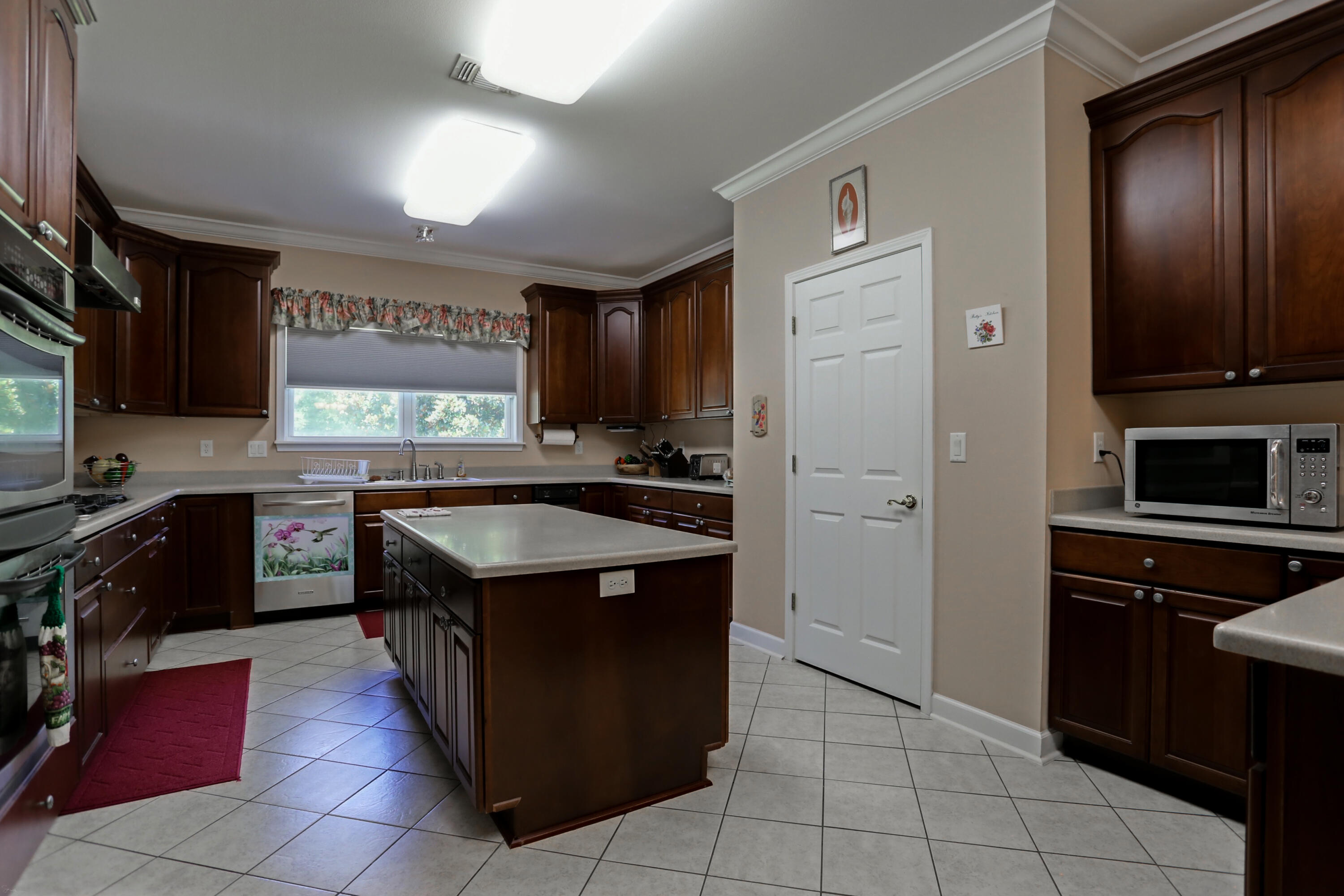 5467 Old River Road Baker, FL 32531 - Photo 28 of 55 a kitchen with kitchen island granite countertop a stove top oven microwave and refrigerator
