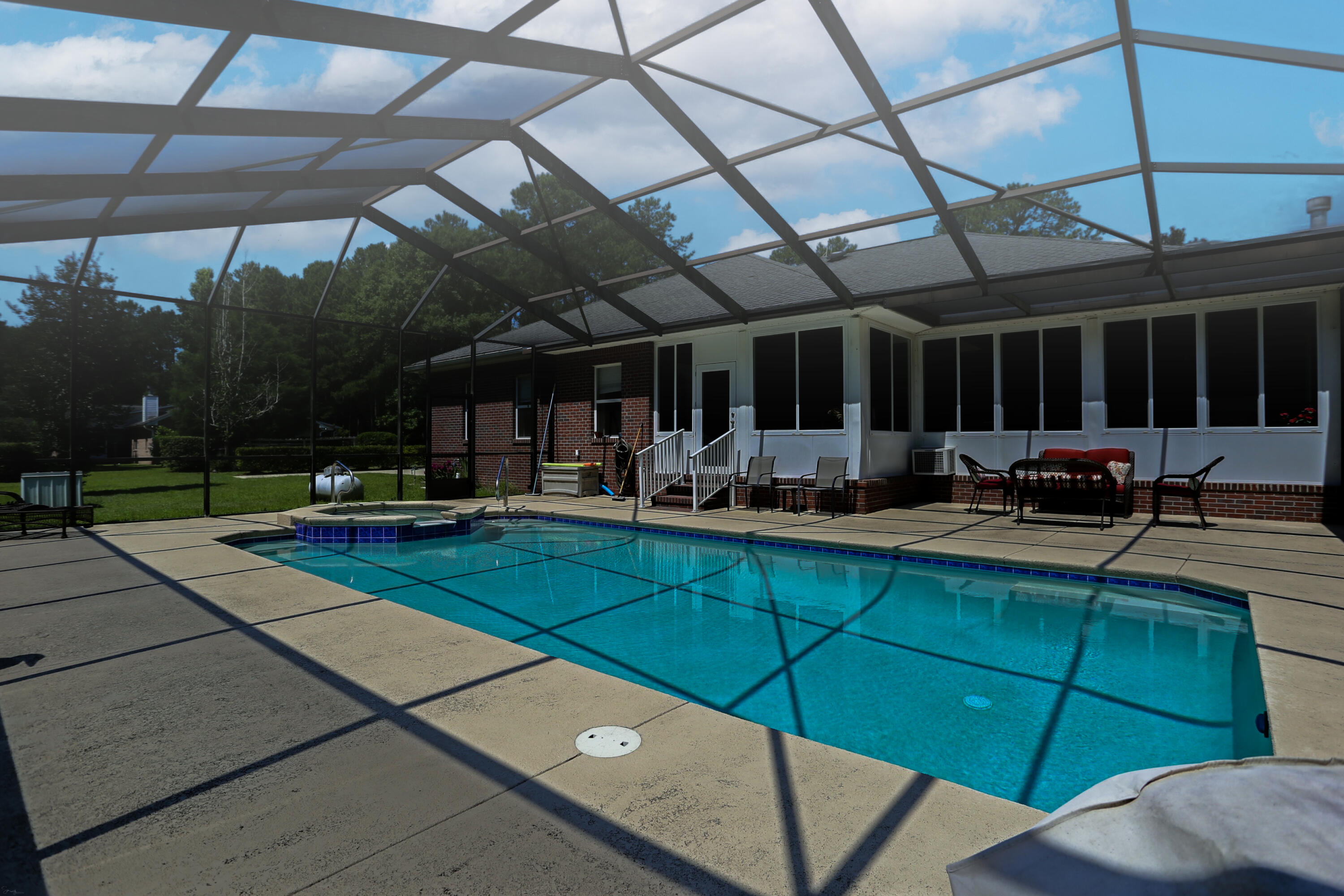 5467 Old River Road Baker, FL 32531 - Photo 47 of 55 a view of a swimming pool with a patio and a garden
