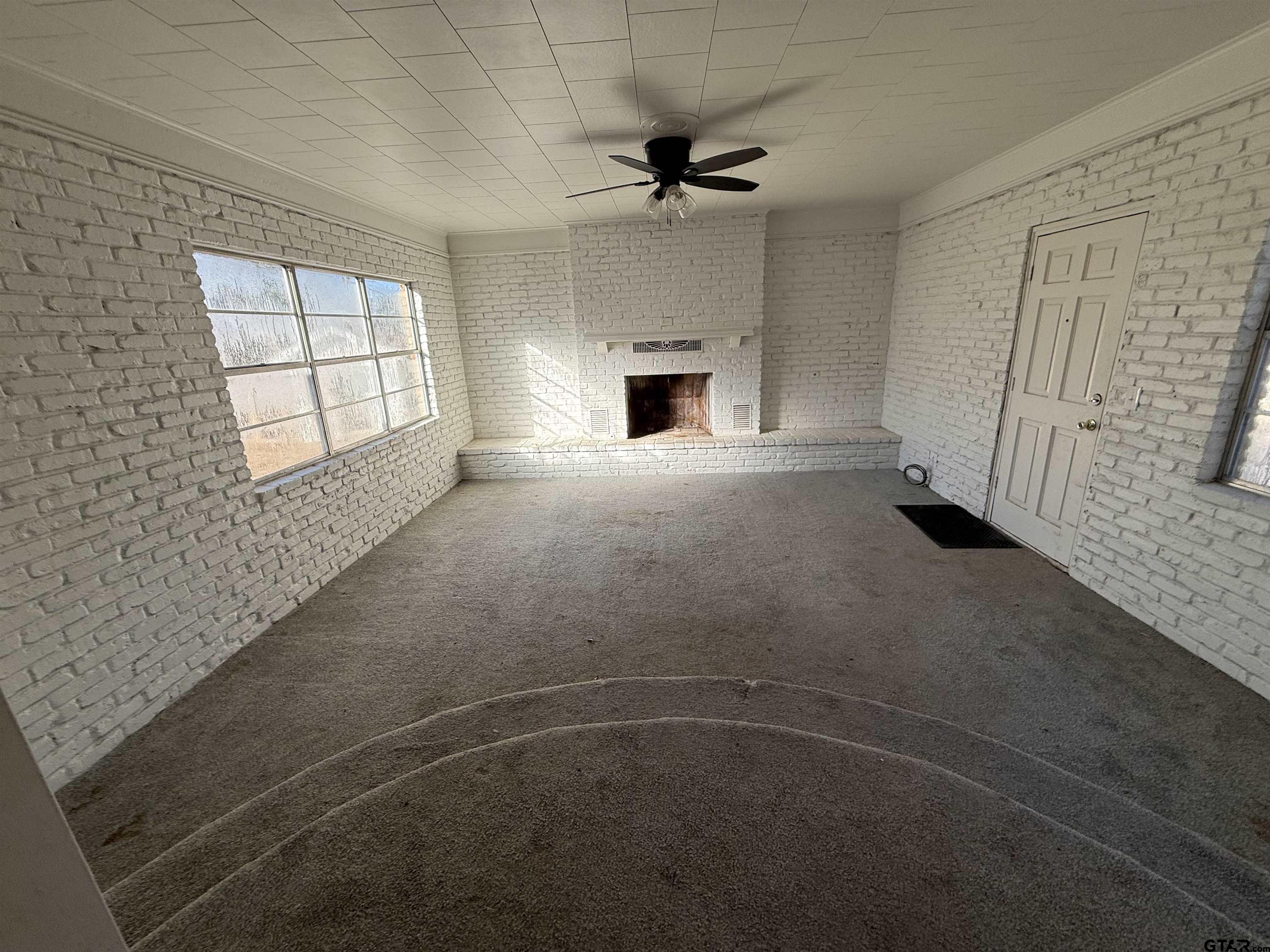 207 South Sun Camp Road White Oak, TX 75693 - Photo 3 of 18 an empty room with windows and fireplace