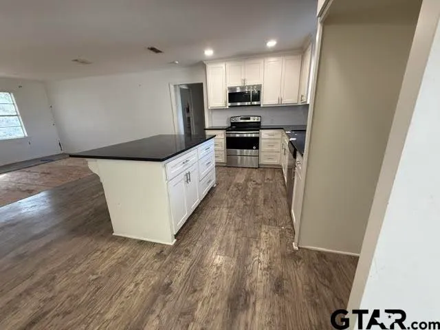 a kitchen with granite countertop a sink and a stove top oven