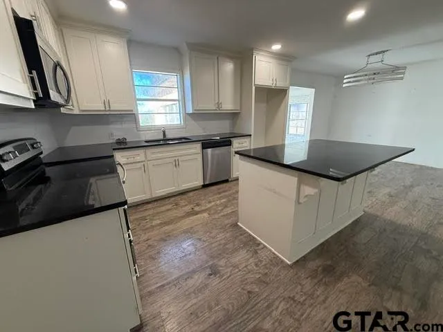 a kitchen with stainless steel appliances granite countertop a stove a sink and a refrigerator