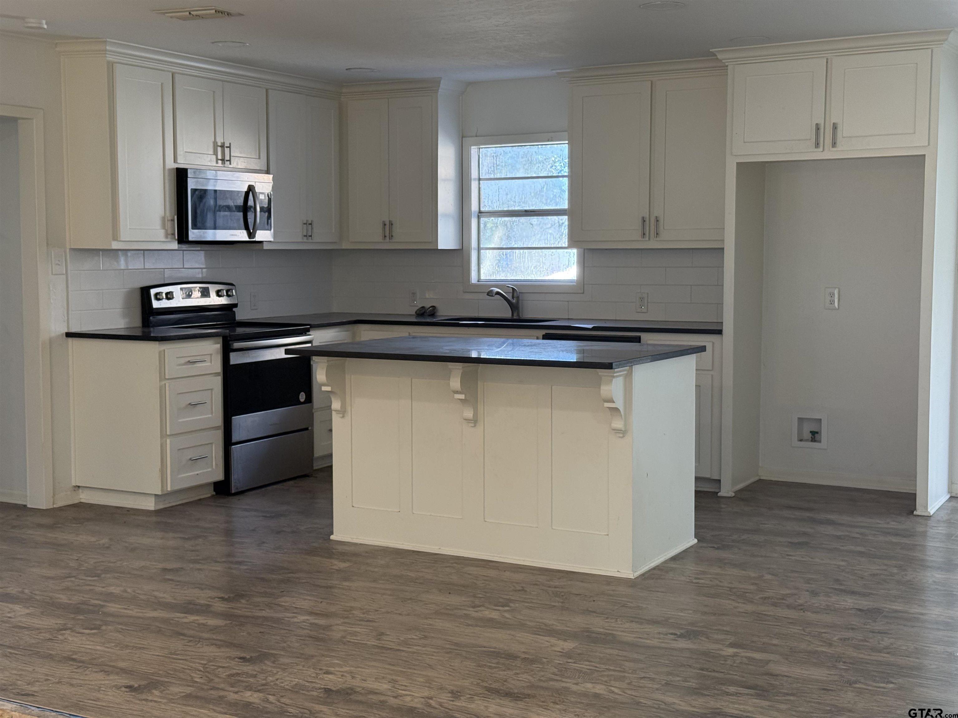 207 South Sun Camp Road White Oak, TX 75693 - Photo 6 of 18 a kitchen with stainless steel appliances granite countertop a stove a sink and a refrigerator