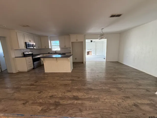 an empty room with windows and fan