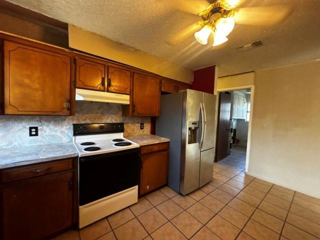 122 Rosa Street Edna, TX 77957 - Photo 12 of 17 a kitchen with stainless steel appliances granite countertop a refrigerator and a stove