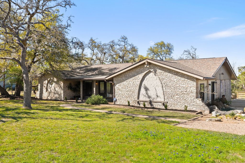 8910 Sam Carter Drive Austin, TX 78736 - Photo 1 of 1 View of front facade featuring a front yard, covered porch, and stone siding