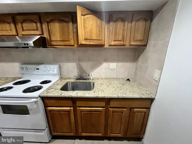 a kitchen with stainless steel appliances granite countertop a sink a stove and cabinets