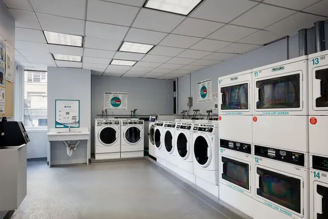 a utility room with stainless steel appliances granite countertop a stove and a microwave