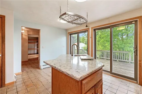 a kitchen with stainless steel appliances granite countertop a stove top oven a refrigerator a sink and dishwasher with a large window