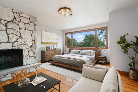 an empty room with wooden floor cabinet and windows