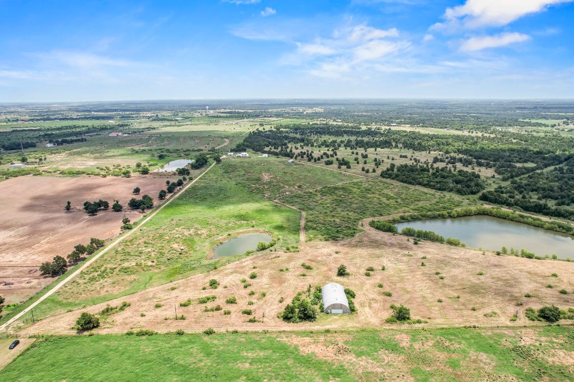 Aerial view of sparsely populated area featuring a nearby body of water and property boundaries highlighted
