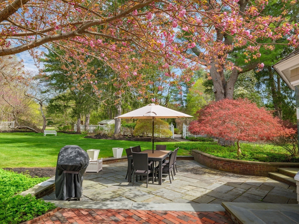 17 Cushing Street Hingham, MA 02043 - Photo 7 of 41 a view of a table and chairs under an umbrella in backyard