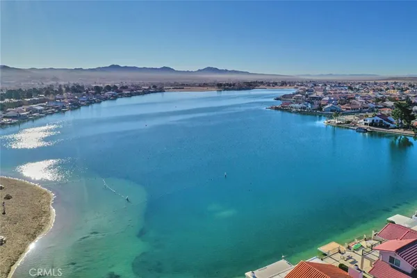 an aerial view of ocean and residential houses with outdoor space